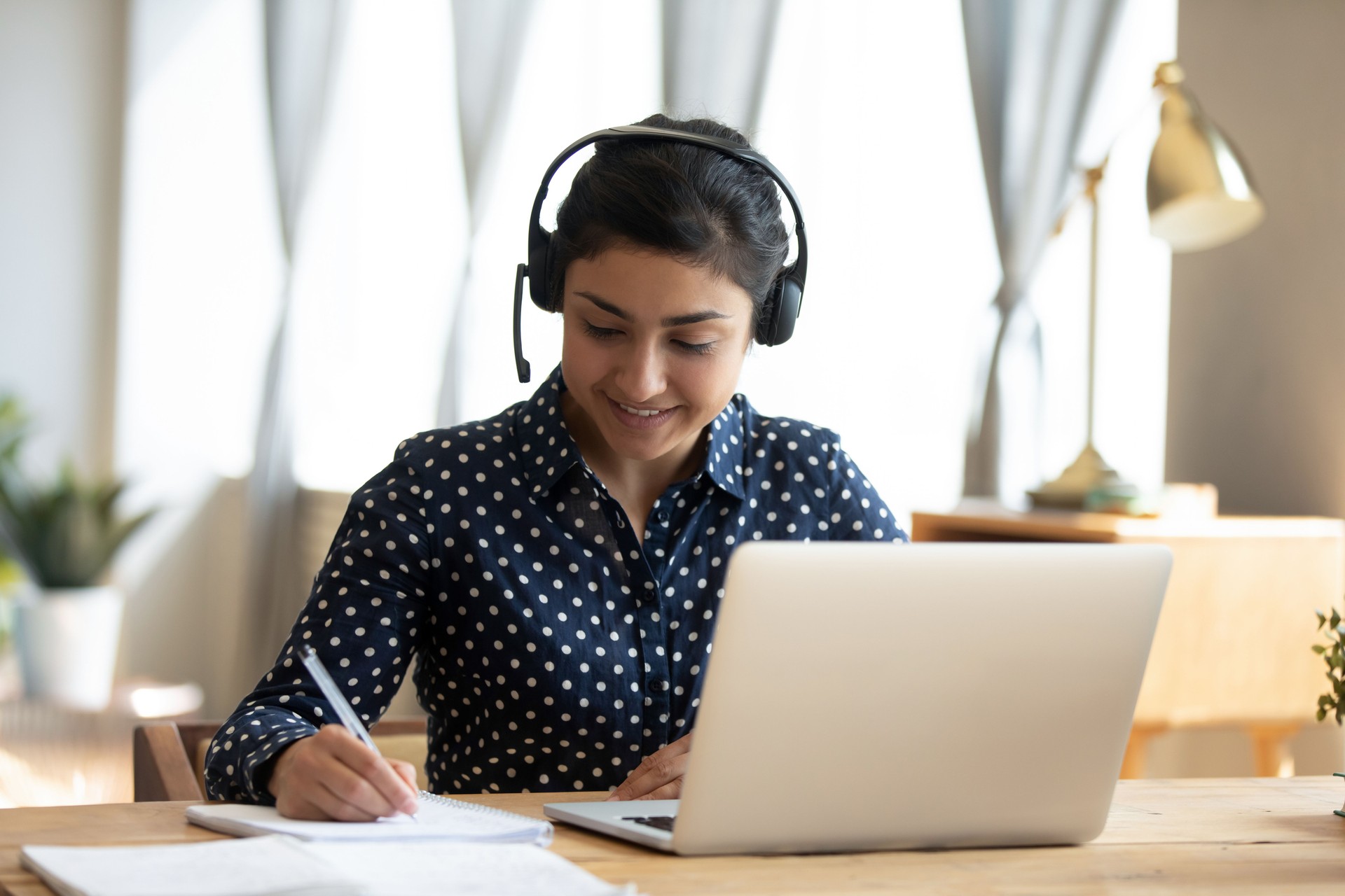 Woman remote interpreter wears headset and takes notes during the proceeding